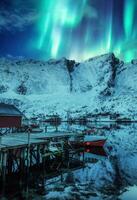 Aurora Borealis, Nord Beleuchtung Über Schnee bedeckt Berg und Angeln Dorf auf Arktis Kreis beim Lofoten Inseln foto