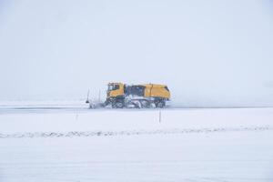 Gelb Schnee Pflüge Pflügen Schnee Startseite Straße im Schneesturm foto