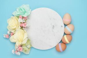 Marmor Kreis mit dekoriert Eier und Blumen auf Blau Hintergrund foto
