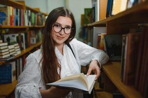 Ausbildung, hoch Schule, Universität, Lernen und Menschen Konzept. lächelnd Schüler Mädchen lesen Buch foto