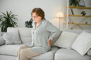 alt Alter, Gesundheit Problem und Menschen Konzept - - Senior Frau Leiden von Schmerzen im zurück oder Zügel beim Zuhause foto