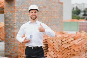 Ingenieurwesen Beratung Menschen auf Konstruktion Seite? ˅ halten Entwurf im seine Hand. Gebäude Inspektor. Konstruktion Seite? ˅ prüfen Zeichnung und Geschäft Arbeitsablauf von Neu Gebäude. foto