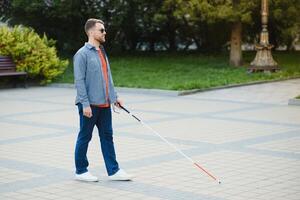 blind Mann. Menschen mit Behinderung, behindert Person und täglich Leben. visuell beeinträchtigte Mann mit Gehen Stock. foto