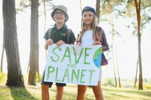 Kinder sind halten ein Poster speichern das Planet. Erde Tag. Lasst uns speichern das Planet von Verschmutzung. foto