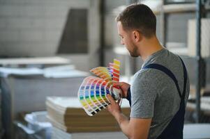 Porträt von Produktion Linie Arbeiter steuern Herstellung Prozess von modern Verpackung industriell Maschine im Drucken Fabrik foto