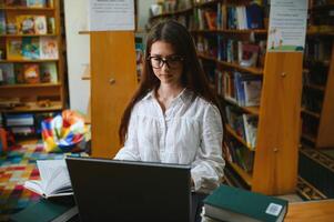 Porträt von ein schön Schüler im ein Bibliothek foto