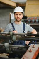 Arbeiter im schützend Kleidung im Fabrik mit Maschine foto