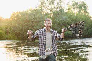 männlich Hobby. bereit zum Angeln. entspannen im natürlich Umfeld. Forelle Köder. bärtig elegant Mann. Mann entspannend Natur Hintergrund. Strategie. Hobby Sport Aktivität. Aktivität und Hobby. fangen und Angeln foto