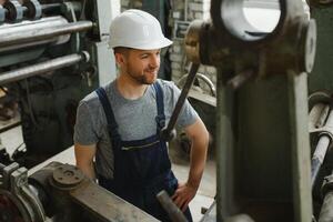 Arbeiter im schützend Kleidung im Fabrik mit Maschine foto