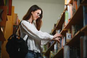 im das Bibliothek - - ziemlich weiblich Schüler mit Bücher Arbeiten im ein hoch Schule Bibliothek. foto