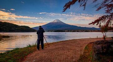 Rückseite Aussicht von Reisender Mann nehmen Foto Fuji Berg und kawaguchiko See beim Sonnenuntergang im Fujikawaguchiko, Japan.