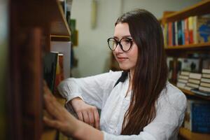 Porträt von ein schön Schüler im ein Bibliothek foto