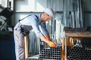 Porträt von Fabrik Arbeiter im schützend Uniform und Helm Stehen durch industriell Maschine beim Produktion Linie. Menschen Arbeiten im Industrie foto