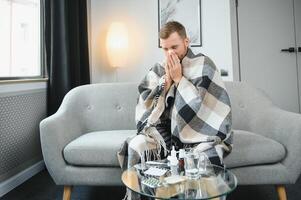 krank Mann auf Sofa beim Zuhause und weht Nase foto