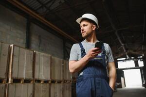 Verwaltung Team, Ingenieur, oder Vorarbeiter. Stehen Überprüfung Job Information Über industriell Produktion Verwaltung innerhalb das Fabrik durch Telefon. Zusammenarbeit Konzept foto