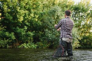 Angeln. Fischer und Forelle. Fischer auf wild Fluss. foto