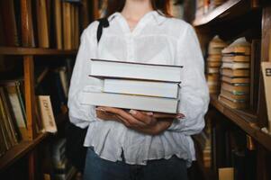 im das Bibliothek - - ziemlich weiblich Schüler mit Bücher Arbeiten im ein hoch Schule Bibliothek. foto