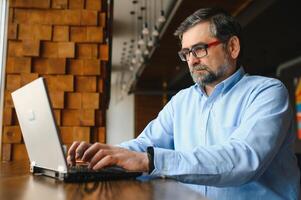 Mann mit Laptop im Cafe Bar foto