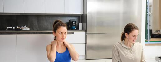 Bild von Frau trainieren beim heim, Dehnen ihr Kopf und Nacken, tut sich warm laufen Übungen Vor Yoga, Fitness Ausbildung im Leben Zimmer foto