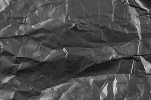 abstrakt Hintergrund zerknittert Plastik Film Textur schwarz Müll Tasche foto