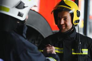 Porträt von zwei heroisch Feuerwehrmann im schützend passen und Helm. foto