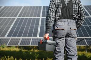 männlich Arbeiter im Uniform draußen mit Solar- Batterien beim sonnig Tag. foto