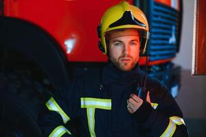 Foto von Feuerwehrmann mit Gas Maske und Helm in der Nähe von Feuer Motor