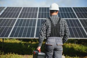 männlich Arbeiter im Uniform draußen mit Solar- Batterien beim sonnig Tag. foto