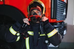 Foto von Feuerwehrmann mit Gas Maske und Helm in der Nähe von Feuer Motor