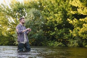 männlich Hobby. bereit zum Angeln. entspannen im natürlich Umfeld. Forelle Köder. bärtig elegant Mann. Mann entspannend Natur Hintergrund. Strategie. Hobby Sport Aktivität. Aktivität und Hobby. fangen und Angeln foto