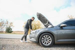 ein Mann Gefühl Stress weil seine Auto ist gebrochen Nieder foto