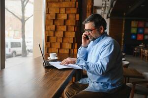 Mann mit Laptop im Cafe Bar foto