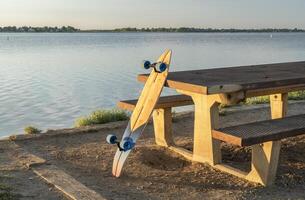 Kreuzfahrt Longboard und ein Picknick Tabelle im Sommer- Landschaft im Nord Colorado - - Junge See Zustand Park foto