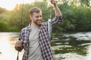 männlich Hobby. bereit zum Angeln. entspannen im natürlich Umfeld. Forelle Köder. bärtig elegant Mann. Mann entspannend Natur Hintergrund. Strategie. Hobby Sport Aktivität. Aktivität und Hobby. fangen und Angeln foto