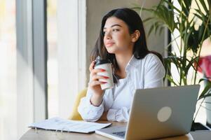 lächelnd Mädchen Schüler Studie online mit Skype Lehrer, glücklich jung Frau lernen Sprache Hör mal zu Vorlesung Uhr Webinar schreiben Anmerkungen aussehen beim Laptop sitzen im Cafe, entfernt Bildung foto