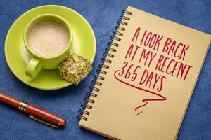 ein aussehen zurück beim meine kürzlich 365 Tage - - ein Hinweis im ein Spiral- Notizbuch mit Kaffee, Ende von Jahr Rückblick Rezension foto