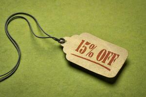 15 Prozent aus - - ein Papier Preis Etikett gegen Grün Hintergrund. Verkauf, Rabatt und Einkaufen Konzept foto