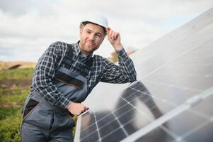 Experte ist inspizieren Qualität von ein Solar- Batterien. Arbeiter im Uniform und Helm mit Ausrüstung. Ökologie Leistung Erhaltung Konzept. foto