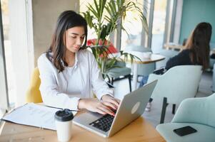 lächelnd Mädchen Schüler Studie online mit Skype Lehrer, glücklich jung Frau lernen Sprache Hör mal zu Vorlesung Uhr Webinar schreiben Anmerkungen aussehen beim Laptop sitzen im Cafe, entfernt Bildung foto