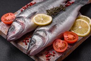 frisch roh Ozean Meer Bass Fisch mit Salz, Gewürze und Kräuter foto