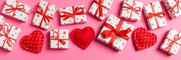 Draufsicht auf Geschenkboxen und rote Textilherzen auf buntem Hintergrund. Valentinstag-Konzept mit Kopierraum foto