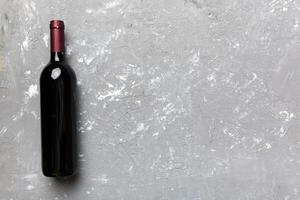 einer Flasche von rot Wein auf farbig Tisch. eben legen, oben Aussicht mit Kopieren Raum foto