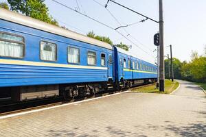 alt Blau Zug ist Verlassen das Plattform beim das Eisenbahn Bahnhof foto