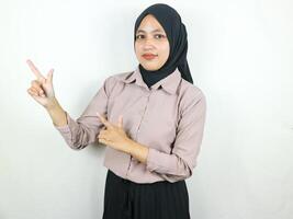 schön asiatisch Muslim Frau im Kopftuch, lächelnd zeigen Finger ein Seite beim Kopieren Raum. foto