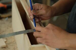 Zimmermann Arbeiten im Werkstatt. Zimmermann Messung mit Bleistift und Herrscher. foto