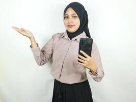 schön asiatisch Muslim Frau lächelnd selbstbewusst mit Hände halten Clever Telefon. Werbung Konzept foto