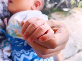 wann ein Erwachsenen Hand sanft hält ein Babys klein Hand, ein unausgesprochen Verbindung ist erstellt, voll von Liebe und Wärme Das kann nicht Sein ausgedrückt im Wörter. diese sanft berühren spiegelt Pflege und Zuneigung. foto