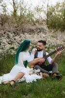 ein bärtig Bräutigam Theaterstücke ein besaitet Instrument und ein Mädchen sitzt im ein Frühling Wiese foto