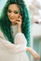 Porträt von ein Braut mit Grün lockig Haar im das Schönheit Zimmer foto