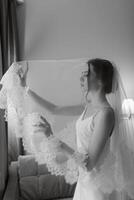 Vorbereitungen für die Braut mit dem Anziehen des Hochzeitskleides foto